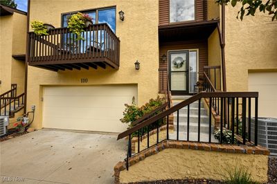 Property entrance with cooling unit, a balcony, and a garage | Image 1