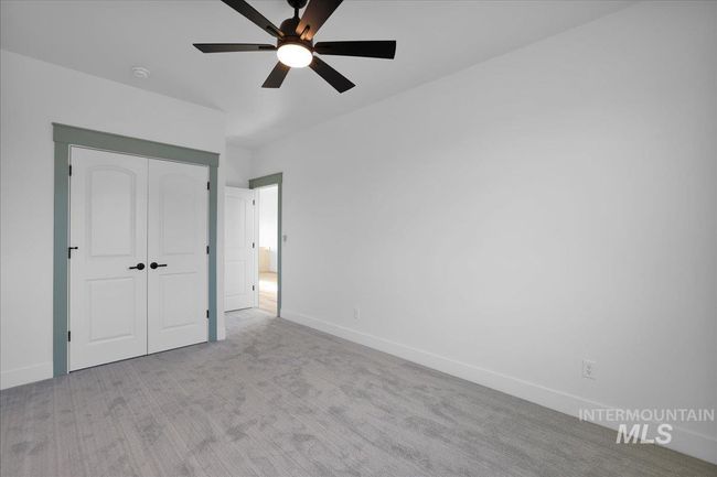 Unfurnished bedroom with carpet flooring, a closet, and a ceiling fan | Image 36