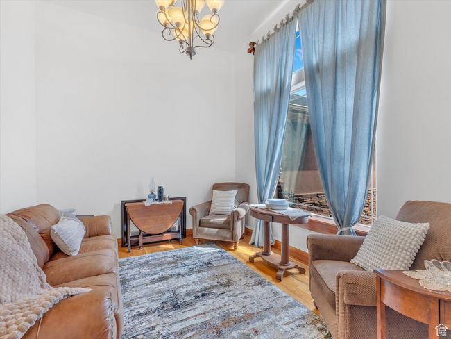 Living area with a notable chandelier and wood finished floors | Image 15