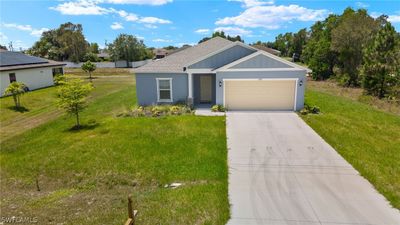 View of front of property with a garage, solar panels, and a front lawn | Image 1