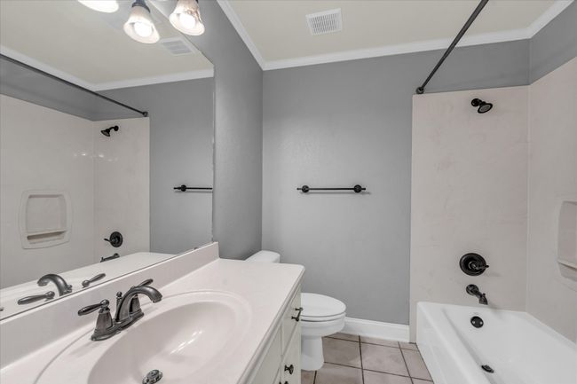 Full bathroom featuring crown molding, vanity, tub / shower combination, and tile patterned floors | Image 27