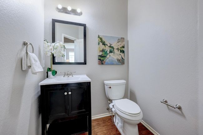 Half bathroom featuring wood finished floors, toilet, vanity, and baseboards | Image 30