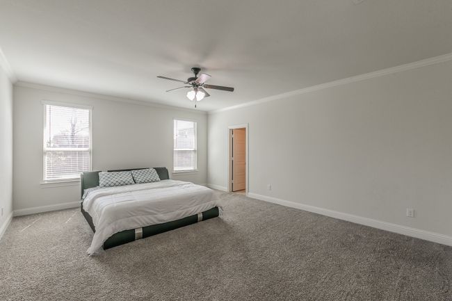 Bedroom featuring light carpet, ceiling fan, baseboards, and ornamental molding | Image 26