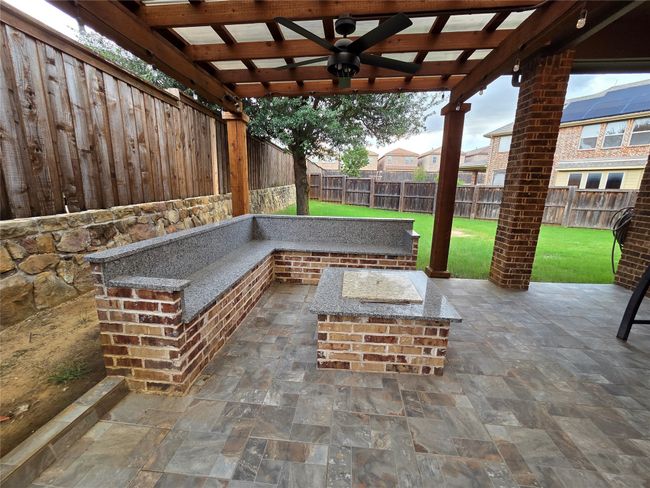 Fenced backyard with ceiling fan, a patio area, and a pergola | Image 15