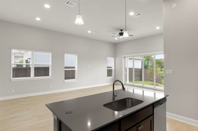 Kitchen featuring open floor plan, ceiling fan, a kitchen island with sink, light wood-style floors, and dishwasher | Image 20