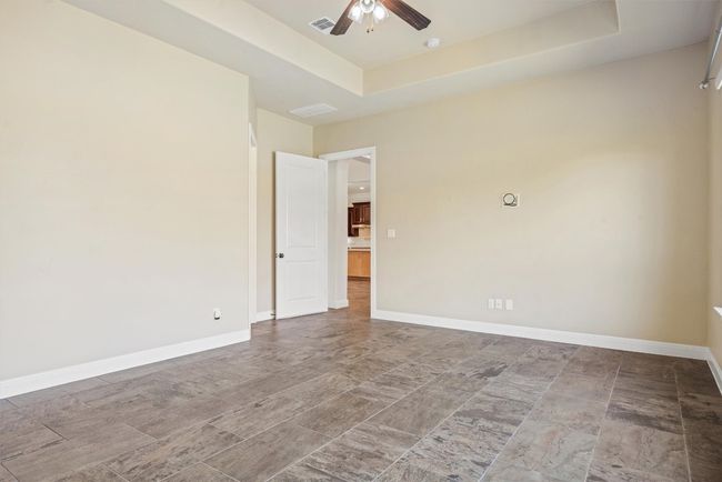 Empty room featuring a raised ceiling and ceiling fan | Image 28