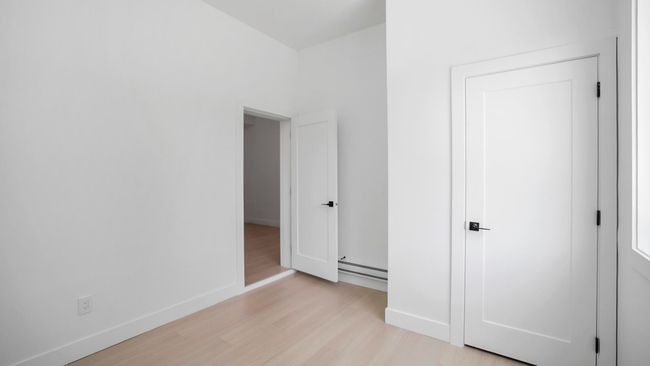 Unfurnished bedroom featuring light wood finished floors, baseboards, and a baseboard radiator | Image 21