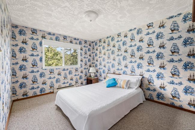 Bedroom featuring a textured ceiling, baseboards, wallpapered walls, carpet floors, and a baseboard heating unit | Image 26