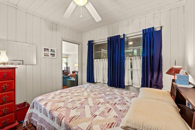 Bedroom featuring a ceiling fan, wood walls, and wood ceiling | Image 14