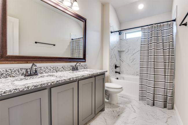 Full bath featuring double vanity, shower / tub combo, and marble finish floors | Image 23
