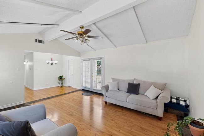 Living room featuring light wood-type flooring, a chandelier, and ceiling fan | Image 18