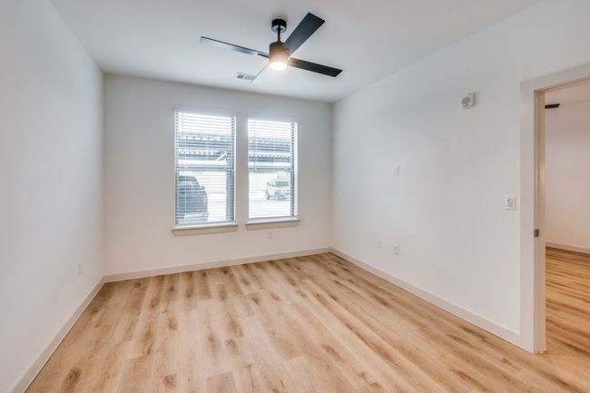 Spare room featuring a ceiling fan, wood finished floors, visible vents, and baseboards | Image 4
