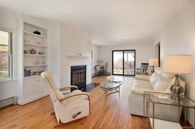 Living room with crown molding, light hardwood / wood-style flooring, and a baseboard heating unit | Image 3