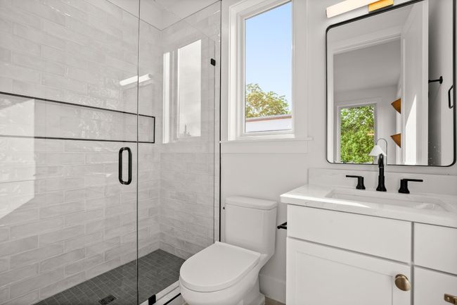 Bathroom featuring toilet, a shower stall, and vanity | Image 8