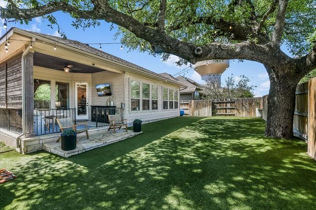 Rear view of property with a patio area, a fenced backyard, a lawn, and ceiling fan | Image 29