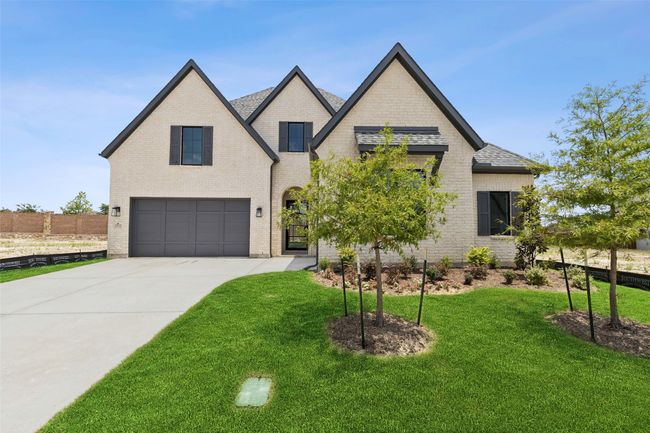 Beautiful brick paired with striking trim and lush landscaping create fantastic curb appeal for this dream home! | Image 4