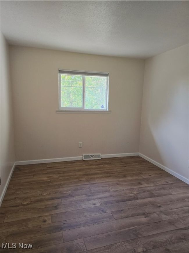 Spare room featuring dark wood-style floors and baseboards | Image 17