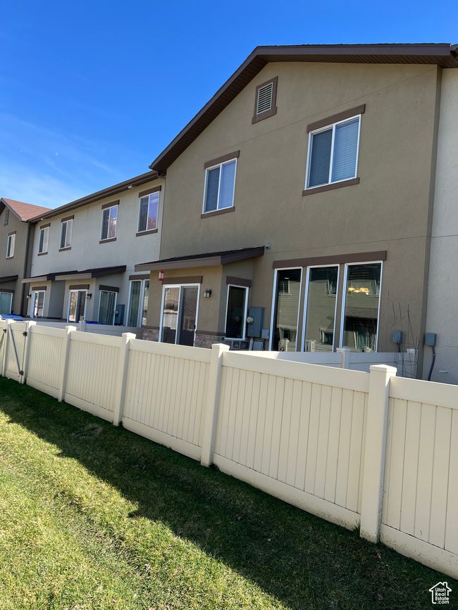 Rear view of property with fence, stucco siding, and a lawn | Image 4