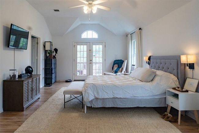 Bedroom featuring light wood-style floors, lofted ceiling, french doors, access to outside, and ceiling fan | Image 30