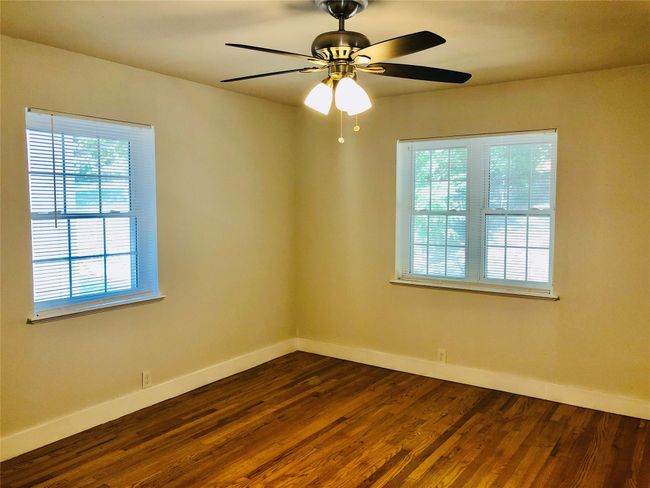 Spare room with dark wood-style flooring and a ceiling fan | Image 15