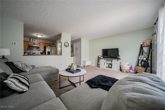 Carpeted living room featuring a textured ceiling | Image 11