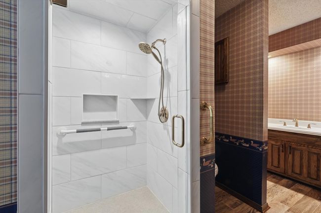 Full bath with wood finished floors, a sink, and a stall shower | Image 26