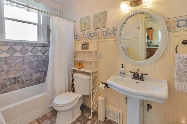 Bathroom featuring toilet and shower / bath combo with shower curtain | Image 39