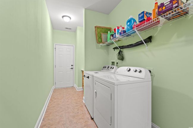 Laundry room featuring light tile patterned flooring, separate washer and dryer, laundry area, baseboards, and visible vents | Image 17