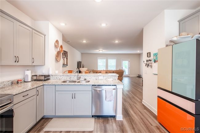 Kitchen featuring stainless steel appliances, a peninsula, light wood-style flooring, recessed lighting, and open floor plan | Image 9