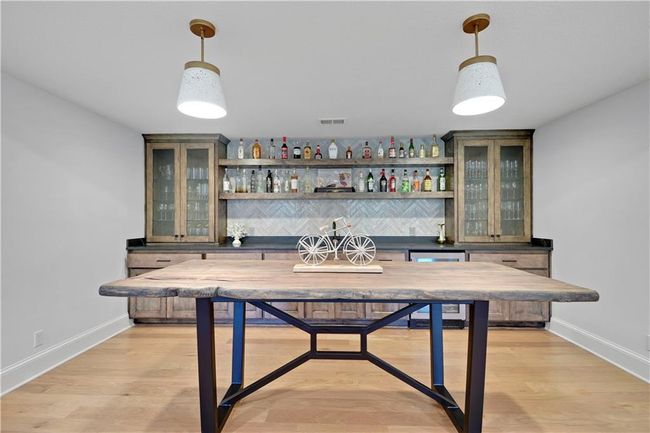Bar featuring wet bar, beverage cooler, visible vents, and baseboards | Image 49