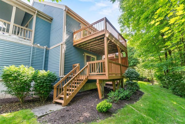 Back of house with a wooden deck, a yard, and stairs | Image 34
