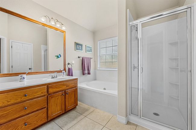 Bathroom with vanity, a shower stall, tile patterned floors, and a bath | Image 21