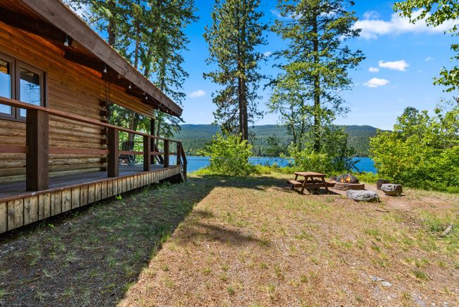 View of yard featuring an outdoor fire pit and a Swan Lake and mountain view | Image 22