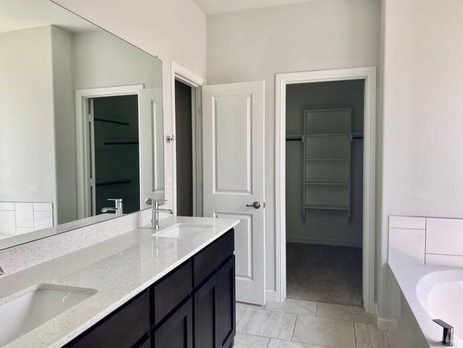 Bathroom with double vanity, a spacious closet, and a bath | Image 13