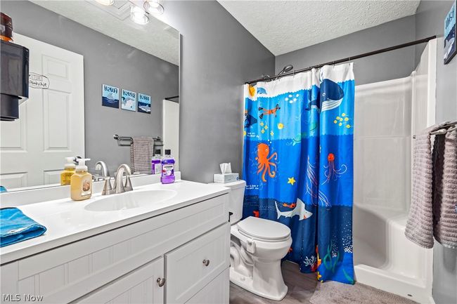Bathroom featuring a textured ceiling, oversized vanity, and toilet | Image 28