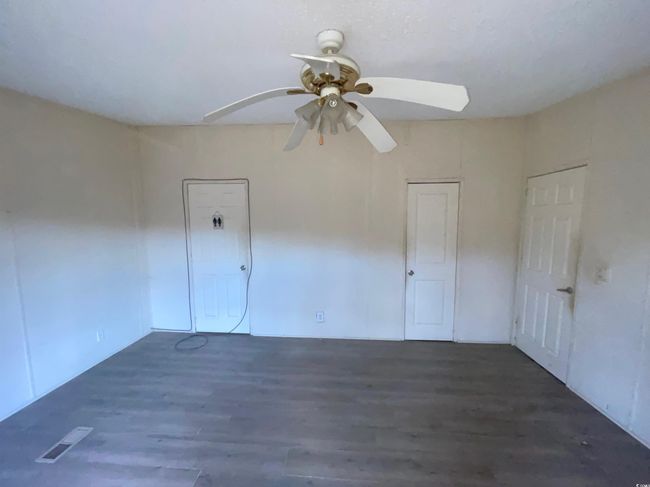 Empty room featuring visible vents, a ceiling fan, and wood finished floors | Image 22