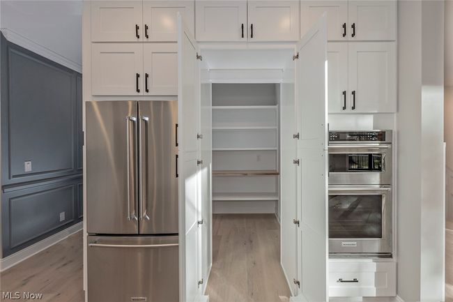 Kitchen featuring appliances with stainless steel finishes, white cabinetry, and light wood-type flooring | Image 26