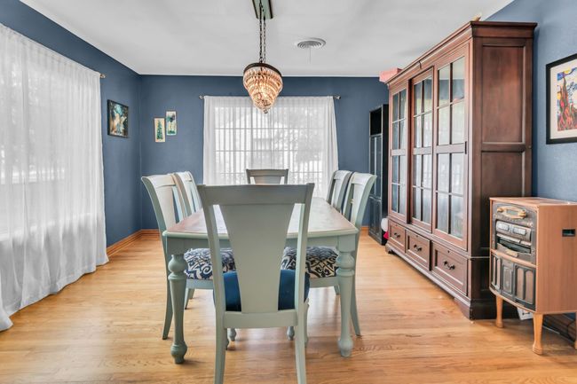 Dining space featuring healthy amount of natural light, a chandelier, and light wood-type flooring | Image 9
