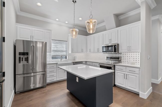 Kitchen with a sink, white cabinetry, stainless steel appliances, and recessed lighting | Image 8