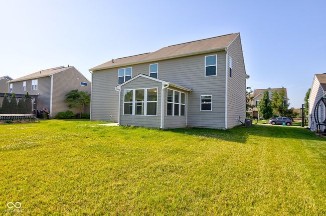 back of house featuring a trampoline and a yard | Image 51
