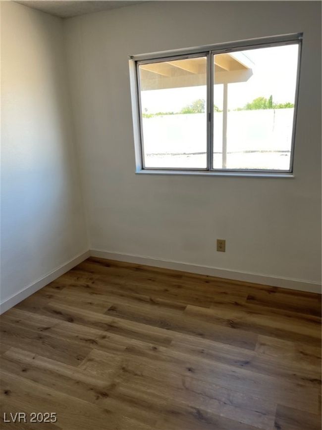 Spare room with baseboards and wood finished floors | Image 10