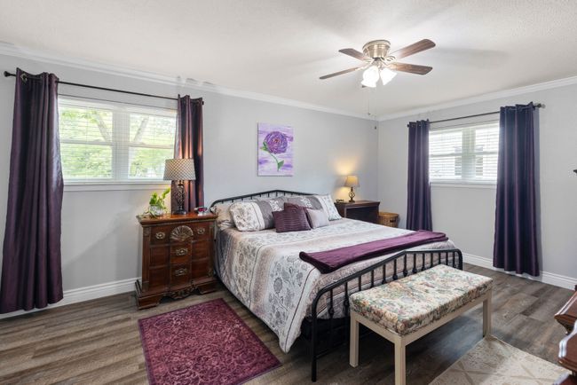 Bedroom featuring wood finished floors, ornamental molding, and a ceiling fan | Image 11