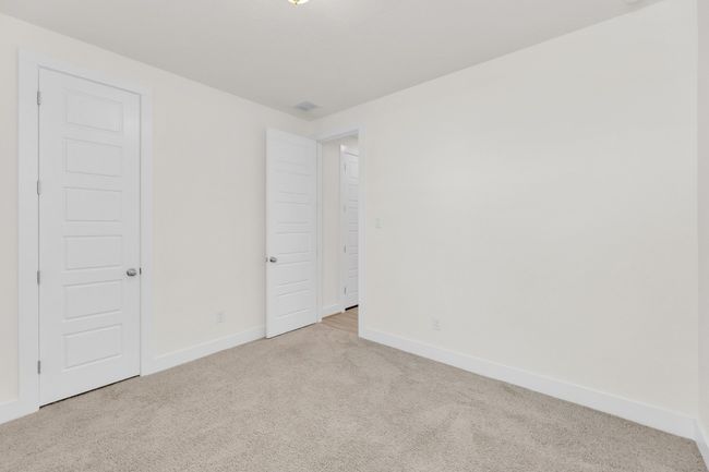 Unfurnished bedroom with carpet, visible vents, and baseboards | Image 32