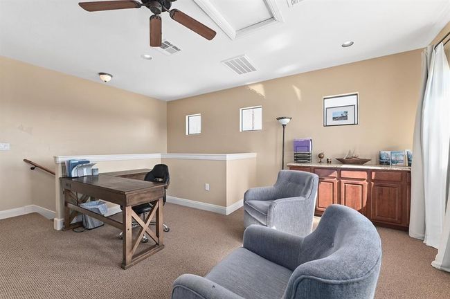 Office with light carpet, baseboards, ceiling fan, and visible vents | Image 17