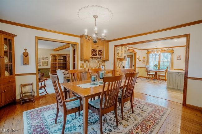Dining room with a chandelier, light wood finished floors, and ornamental molding | Image 10