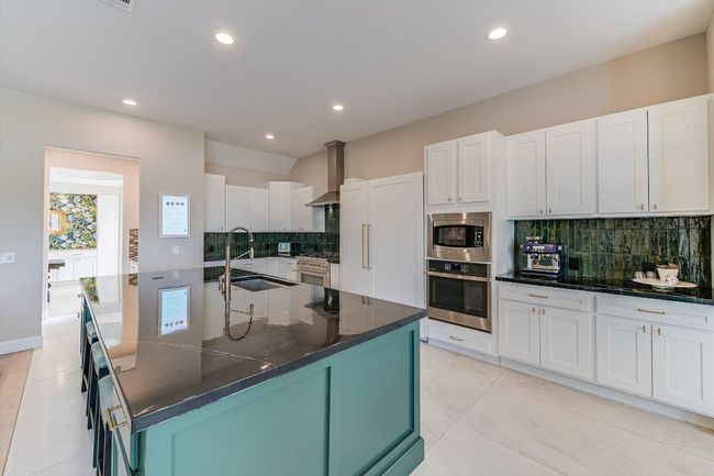 Custom oversized tile in kitchen with designer backsplash. (Hearth Display on kitchen wall does NOT convey.) | Image 13