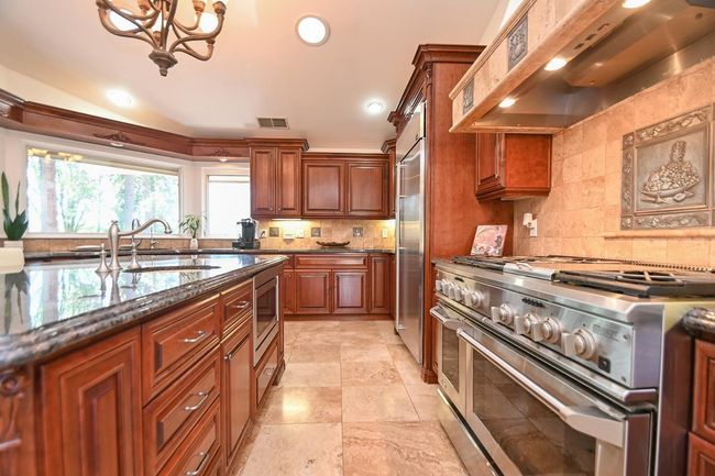 Plenty of cabinets, microwave in center island. | Image 24