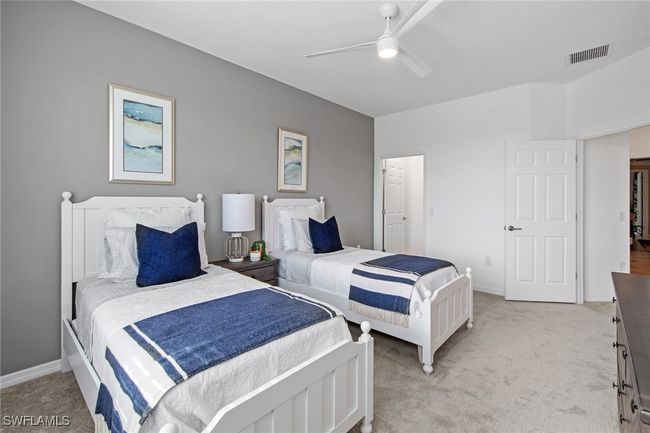 Bedroom featuring light colored carpet, baseboards, a ceiling fan, and visible vents | Image 27