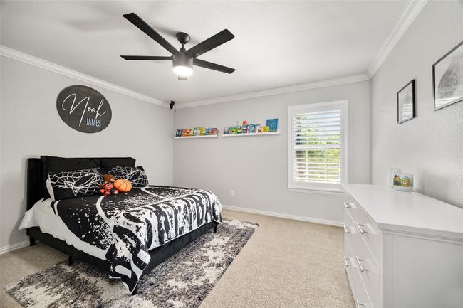 Bedroom featuring light carpet, baseboards, crown molding, and a ceiling fan | Image 24