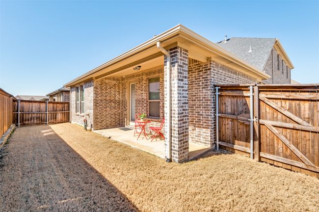 Private fenced backyard featuring a covered patio and a beautifully maintained lush green lawn, perfect for outdoor relaxation and entertainment. | Image 31